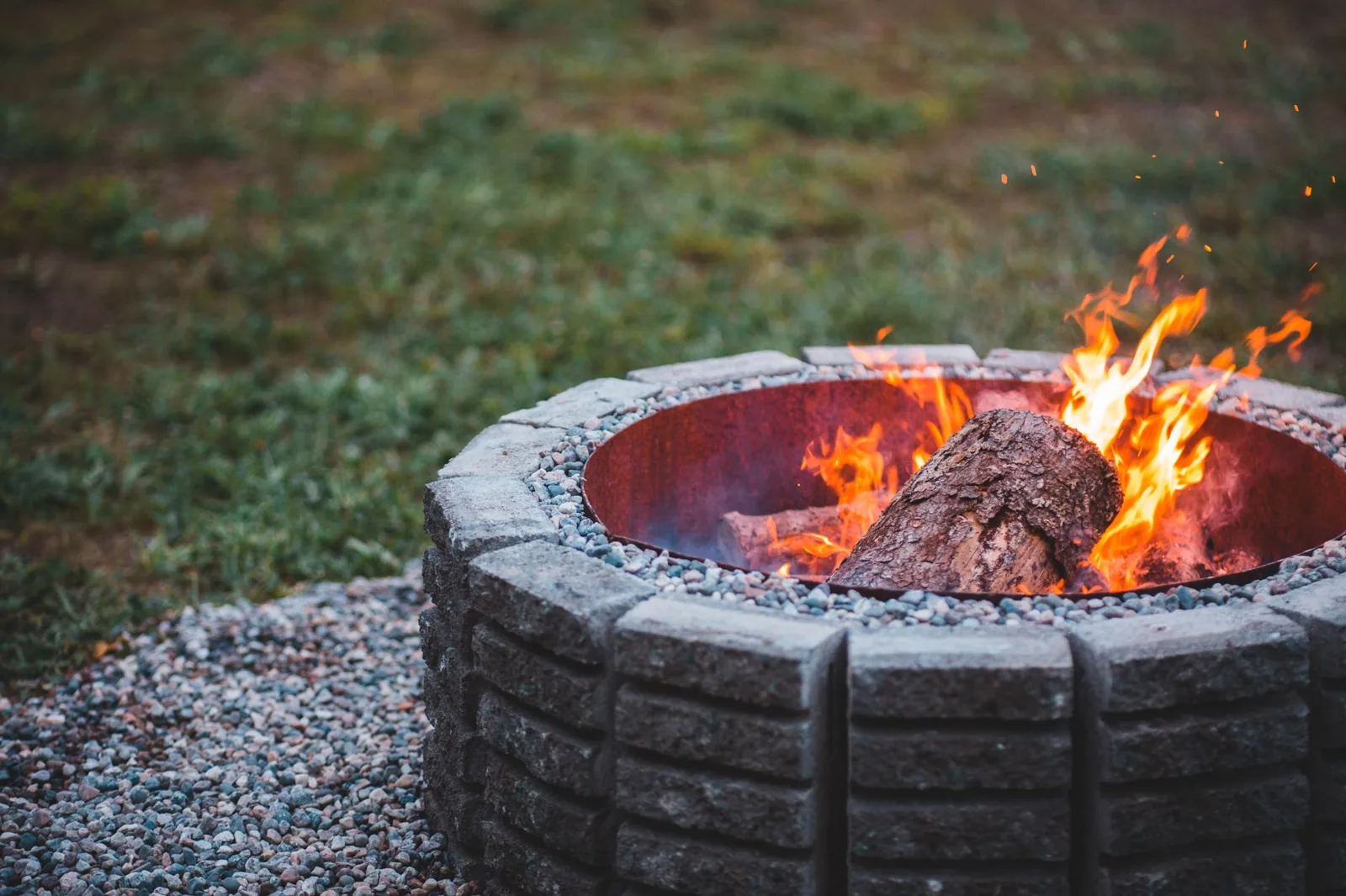 Backyard fire pit ideas in a finished paver patio with stone seating