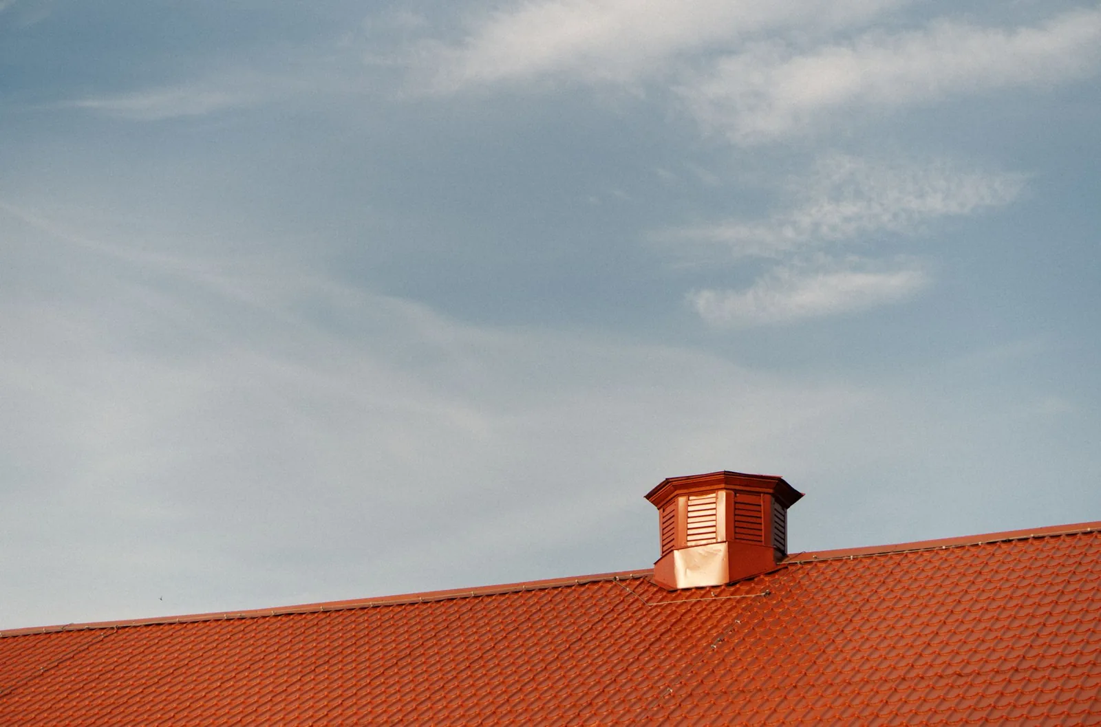 Metal roof vs shingles cost comparison: standing seam panels next to architectural asphalt shingles