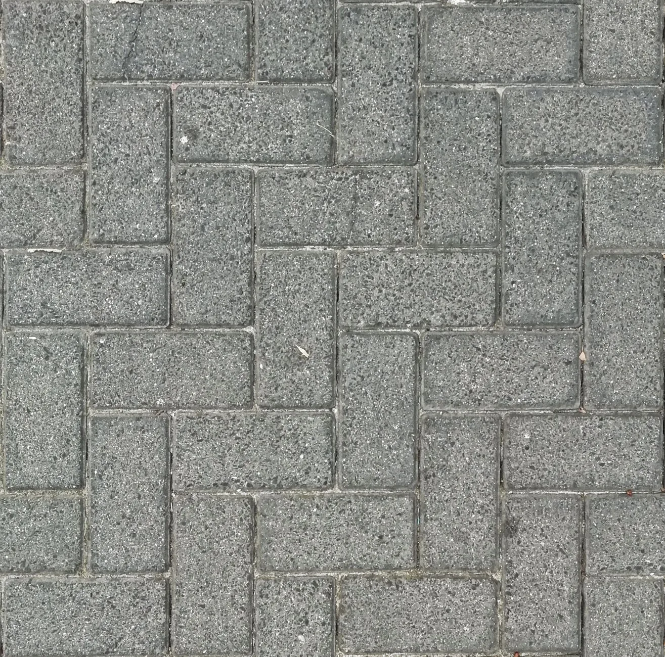 Concrete pavers arranged in a herringbone pattern for a backyard patio