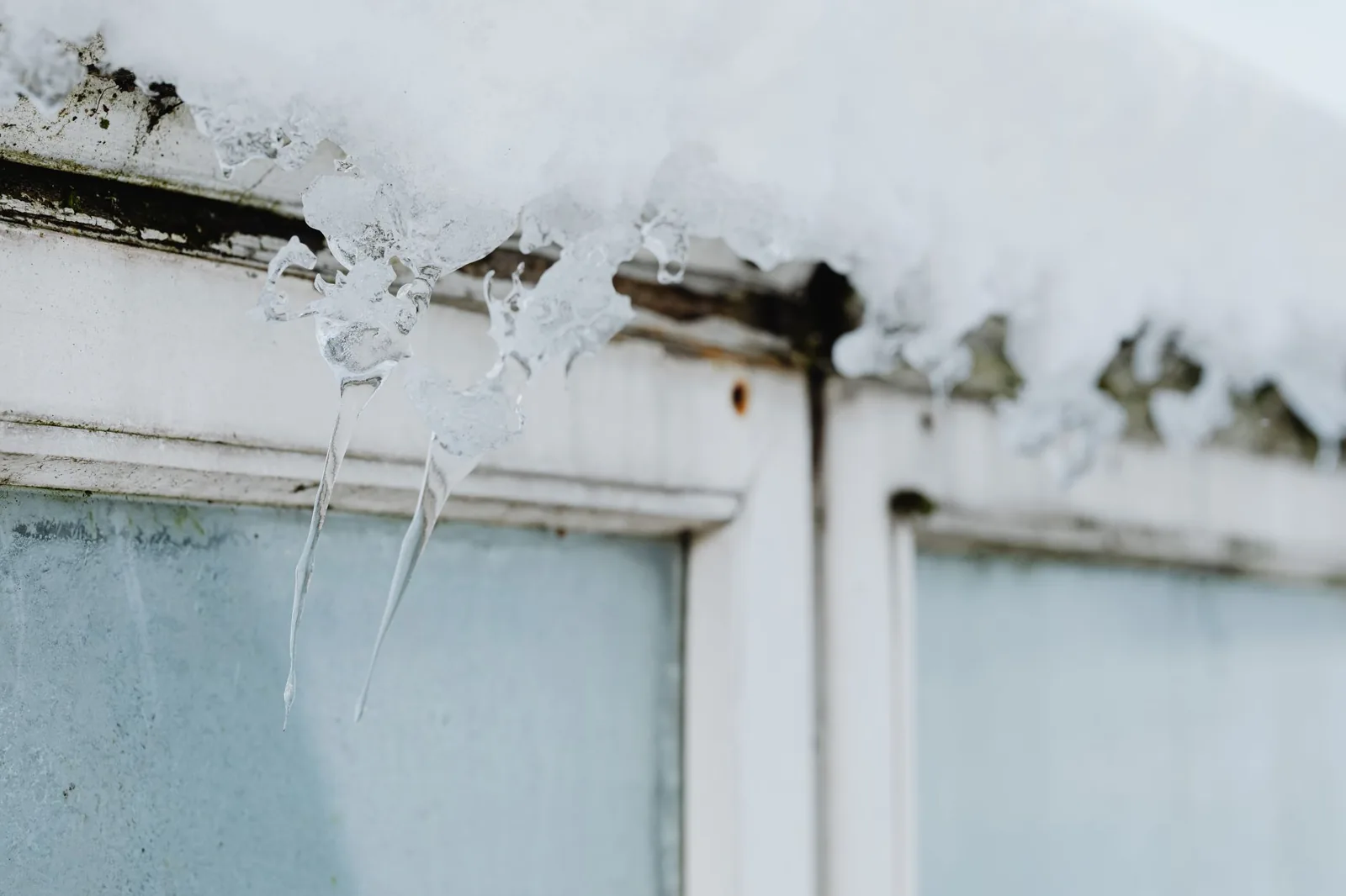 Weatherproofing a window frame with caulk to stop winter drafts