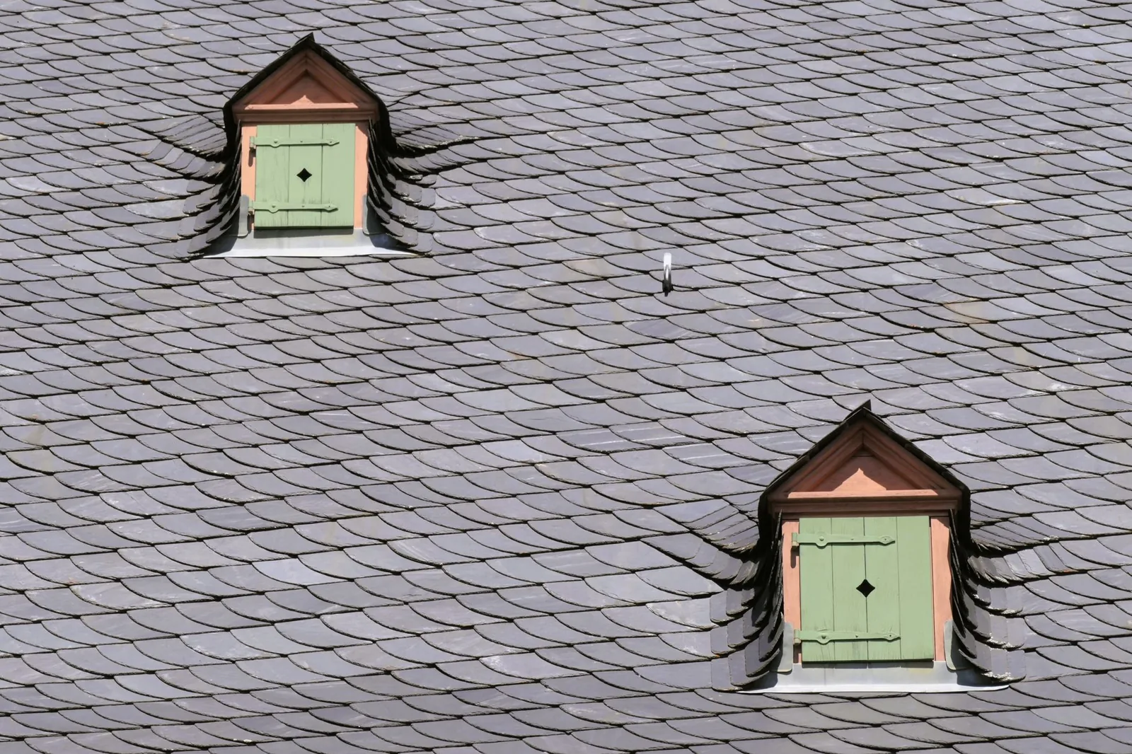 Close-up of metal roof panels being installed over new underlayment